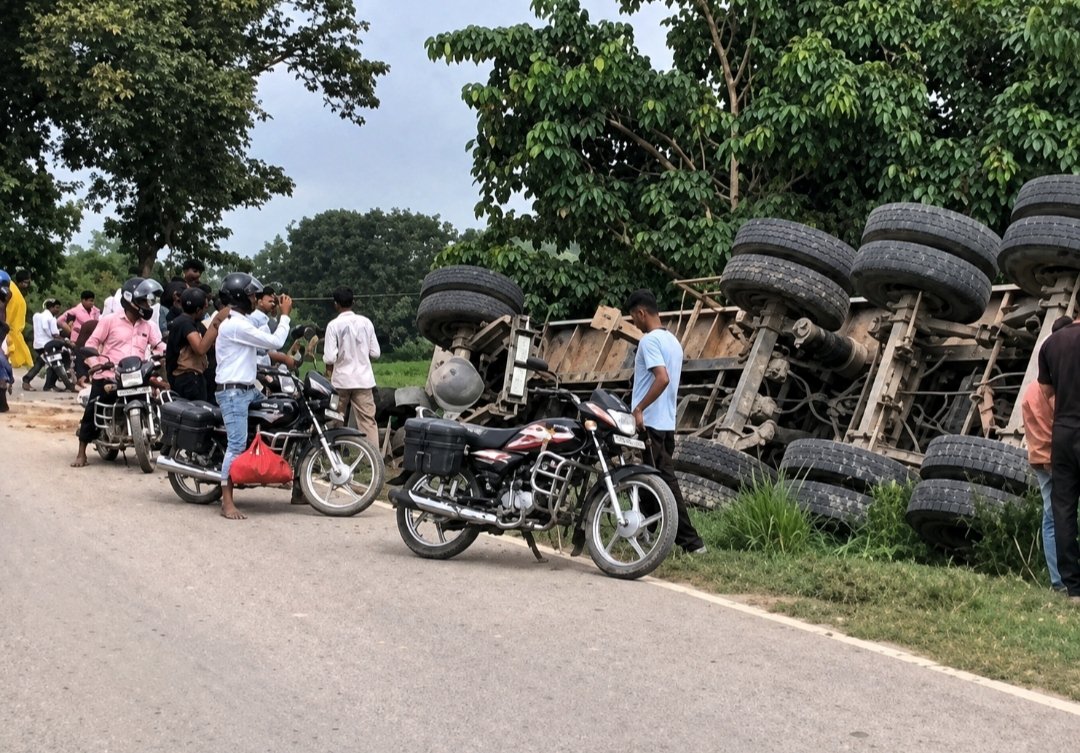 बेलवाकाजी पुल पर मोरंग लदा ट्रेलर पलटा, रेलिंग तोड़कर सड़क किनारे जा गिरा; रात में बैट्री चोरी का आरोप